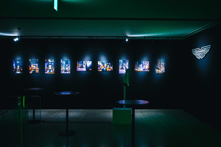 会場を飾る、東京の街なかを行く「アストンマーティンDBX707ミッドナイト ポディウムエディション」の写真。