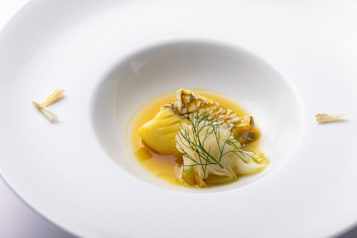 ４皿目「マクブとウイキョウのスープ」。マクブは学術名シロクラベラという沖縄三大高級魚のひとつ。フカフカとした白身の食感とパリパリとしたウロコの歯ごたえが特徴的。