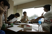 完熟走行のロガーデータを参考に、GTドライバーの影山正美選手にアドバイスをもらう二玄社チーム。真実を語るデータに、一同口を閉ざす。しかしここでのコメントが決勝ヒートの走りに活かされたのである。