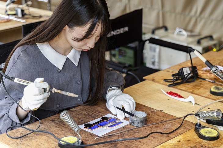 「ディフェンダー90」をモチーフとしたステンドグラス制作体験の様子。各種ワークショップでは、プロの講師がていねいにフォローしてくれるので、初心者でも安心して参加できる。