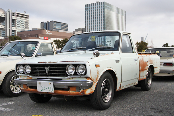 1976年「トヨタ・ハイラックス」。ダットラこと「ダットサン・トラック」に対抗する小型ボンネットトラックとして、1968年に誕生したハイラックス。これは1972年に登場した2代目の後期型。1.6リッター直4 OHVエンジンを積む。
