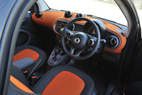 オレンジが大胆に用いられたラバオレンジ仕様のポップな室内。インパネやドアには楕円（だえん）形のモチーフが反復される。ステアリングホイールは本革巻き。