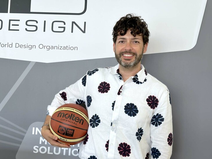 イタルデザイン社ビジネス開発担当のフィオレンツォ・ピラッチ氏。日本のスポーツ用品／自動車部品メーカーであるモルテン向けに同社がデザインした、公式競技用バスケットボール「GL7」（2005年）と。2024年7月、筆者撮影。