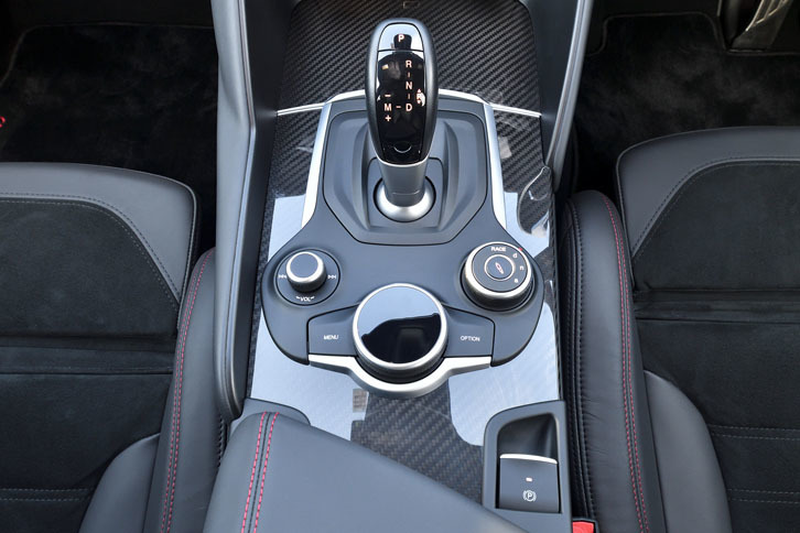 トランスミッションは8段のトルコン式AT（ZF 8HP）。シフトセレクターの手前右側に「アルファDNAドライブモードシステム」のセレクター、その手前に車載インフォテインメントシステムのロータリーパッドが備わる。