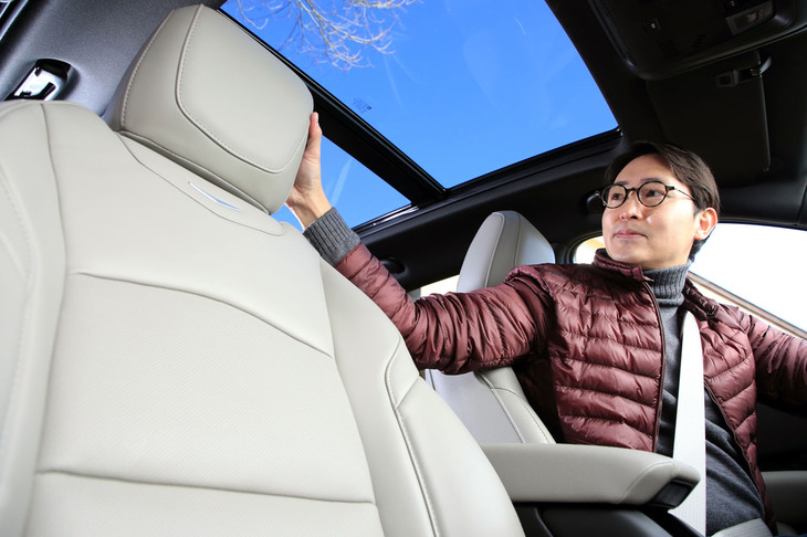 シート表皮をチェックする神戸氏。「プラチナム」では、開放感のあるパノラマ電動サンルーフも標準装備となる。