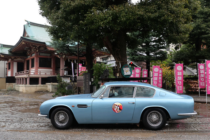 境内を走り抜ける1971年「アストンマーティンDB6 Mk2」。今戸神社は縁結びスポットのほか、招き猫発祥の地のひとつということでも知られている。