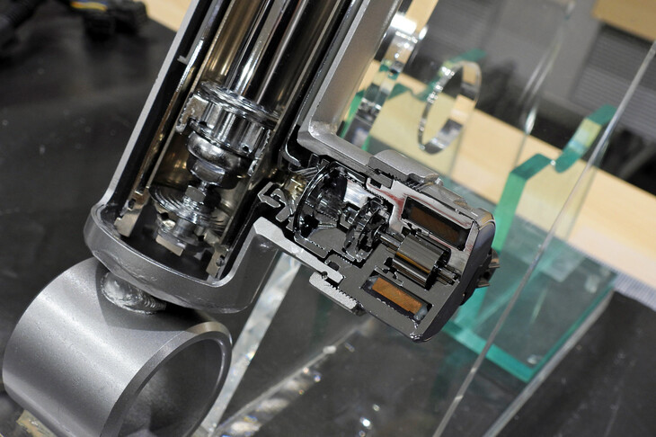 ソレノイドバルブ（写真）を用いた可変ダンパーは、制御の緻密さや応答性の高さに加え、モーターの駆動音がないことによる静粛性の高さも特徴とされる。また安全面では、電源失墜時に機械的にミディアム減衰に固定される特性があり、これがフェイルセーフとして機能する。