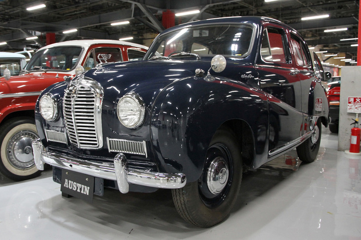 1953年「日産オースチンA40サマーセットサルーン」。戦中・戦後の乗用車開発の技術的空白を埋めるため、日産は英国オースチンと技術提携を結び、1953年から同社の「A40サマーセットサルーン」のライセンス生産を開始した。この個体は同年4月4日に誕生したオフライン1号車そのものだそうで、すべて英国から輸入した部品で組み立てたコンプリート・ノックダウンである。