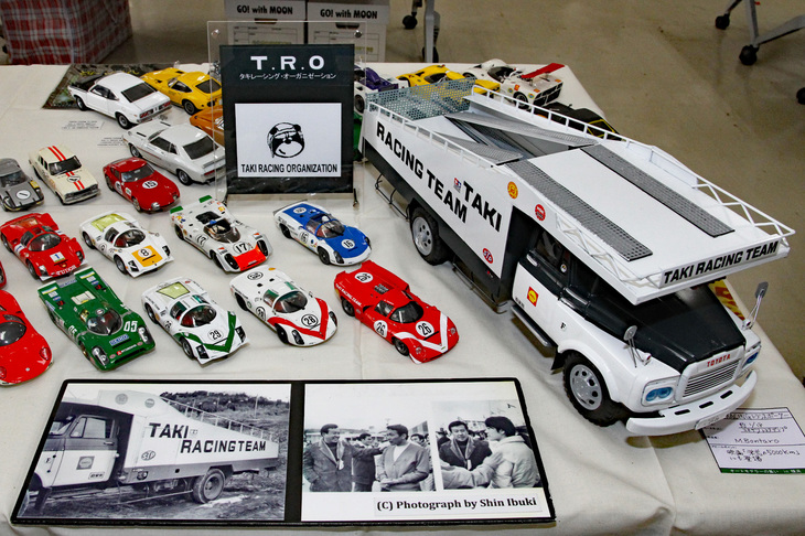右端は、往年の米沢玩具の「トヨタ・ダンプトラック」のティントイをベースにした、タキレーシングチームのトランスポーター（スケールはおよそ1/18）。その左側にズラリと並んだタキレーシングのマシンを中心とする60年代のレーシングカーは、1/32のスロットレーシングカーのボディーを使っている。