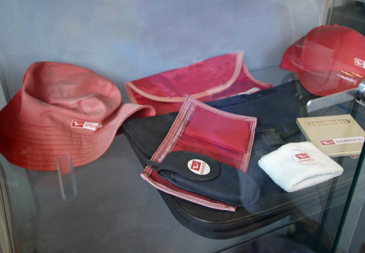 ある元ダイハツディーラーに残されていたオフィシャルグッズ。退色はさておき、手前の携帯電話ケースが時代を感じさせる。