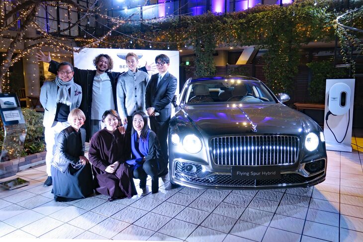 素晴らしい歌声で「ベントレー・フライングスパー ハイブリッド」のお披露目に花を添えたボーカルグループ「VOJA-tension」のメンバーと、ベントレー モーターズ ジャパンの横倉典氏（後列右端）。自動車ライターの大谷達也氏（後列左端）は、日本のラグジュアリーマーケットにおけるハイブリッド車の可能性についてベントレーのアラン・ファビー氏に問われ、「高齢層のオーナーはパワフルなエンジン車を好んで購入するが、日本でも若い世代のオーナーは増えており、彼らはハイブリッドのパワートレインをネガティブに捉えていない。そうした層がより増えれば、ラグジュアリーカーのマーケットでもハイブリッドは広がるのでは」と回答した。