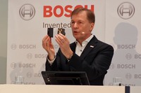 運転支援システムに用いられる次世代レーダー（写真左側）と従来型レーダー（同右側）を手に、その進化を説明するメーダー社長。