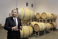 熟成途上のワインが眠る樽の前で甲州種の歴史を語る三澤茂計社長。
    