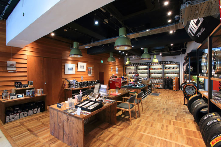 落ち着いた雰囲気がただようポディウムカフェの物販エリア。日欧ブランドのドライビングシューズやグローブなどに加え、プロが撮影した希少なクルマの写真なども販売されている。