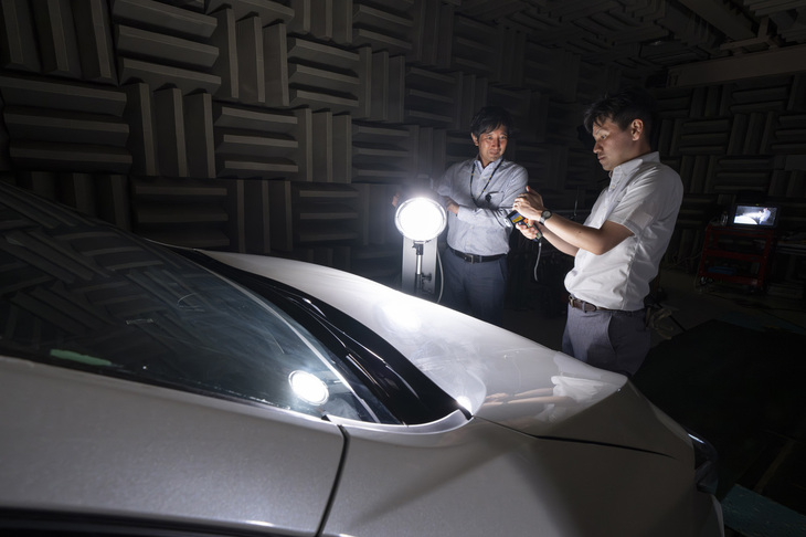 日産自動車総合研究所で行われている「自動車用自己放射冷却塗装」の開発風景。現在のカラーは白のみのだが、量産化を目指しカラーバリエーションの拡大や薄膜化、エアスプレーでの塗布やクリアトップコートの使用、品質基準の向上などに取り組んでいる。まずはトラックや救急車を含む、商用車への特装架装としての採用が検討されている。