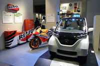 家庭用ガスエンジンコージェネレーションユニットを採用した、未来の家庭のガレージを表現。壁際には、バイクと同じレプソルカラーの蓄電池や貯湯タンクなどが並ぶ。
    