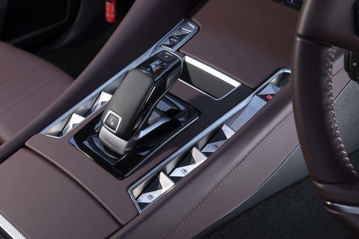 サイドウィンドウの開閉スイッチやロックスイッチはシフトセレクターまわりに集約。凹凸のある装飾にはクル・ド・パリ（ギョーシェ彫り）と呼ばれる手法が使われている。