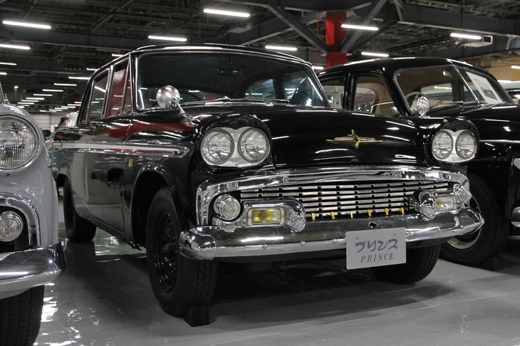 1961年「プリンス・スカイライン1900デラックス」。1957年に登場した初代スカイラインは、当時の小型車規格（5ナンバー）いっぱいの1.5リッターエンジンを搭載していたが、1961年に規格が2リッターに拡大されたのを受けて1900シリーズが追加設定された。デュアルヘッドライトは、1960年のマイナーチェンジの際に兄弟車だった「グロリア」と同時に採用されたもので、国産乗用車ではこれが初だった。