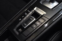 走行モードの選択スイッチや、排気音の調節スイッチなど、各種の機能ボタンが整然と並ぶ、センターコンソール。中央に見えるのは、ルーフの開閉スイッチである。
    