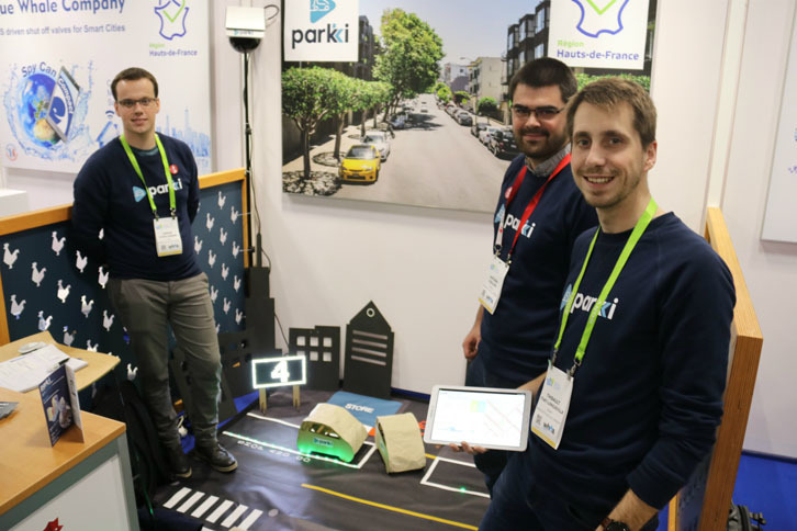 フランスのスタートアップ企業、パーキイのメンバー。「センス」と名付けられた装置は、路上の簡易センサー（左奥）を使って、100m以内で行われている約80台の路上駐車を探知することが可能。カメラを使わないため、プライバシー保護の問題もクリアしやすいという。