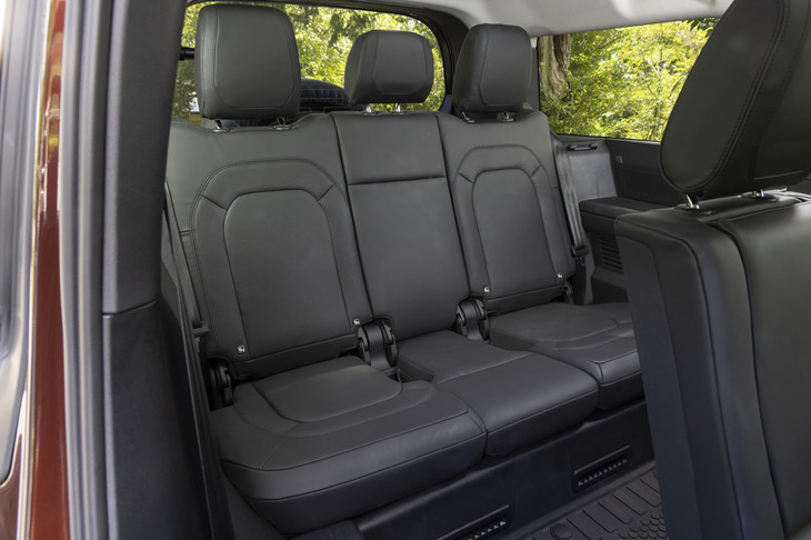 市販されるSUVで唯一となる3人掛けの3列目シートが備わる「ディフェンダー130」。座面は決して高くはないが、体育座りになるほど低くもないレベルに設定されている。シートの左右にはドリンクホルダーも備わる。背もたれには40：20：40の分割可倒機構が組み込まれている。