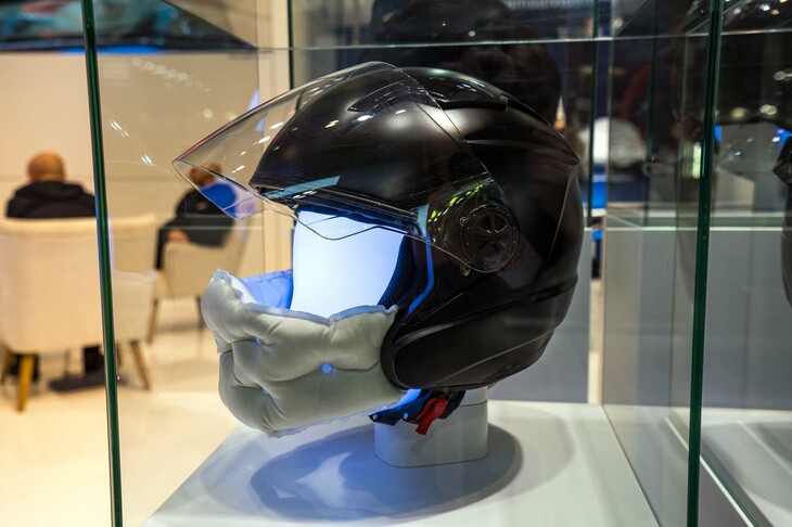 スウェーデンで自動車用のエアバッグとエアバッグシステムを開発するAutoliv（オートリブ）。2022年のEICMAでは、イタリアのヘルメットブランド、Airoh（アイロー）と共同開発中のヘルメット内蔵エアバッグを発表しており、いまも研究を続けているという。そのオートリブは、EICMA 2023でエアバッグを使った新しいプロテクターを発表。そのひとつが、オープンフェイスヘルメット用のエアバッグだ。