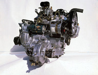 シリンダーヘッド、同ブロック、クランクケースからトランスミッションケース、クラッチハウジングまでアルミ合金によるダイキャスト製で、「白いエンジン」と呼ばれたDA型エンジン。写真は搭載位置に対して前方から見たところで、ファイナルドライブ（デファレンシャル）が手前にあることからおわかりのように、エンジンは後車軸より後方に横向きにオーバーハングされる。