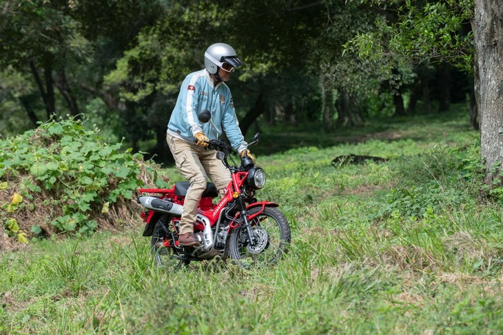 草の生い茂るオフロードを走る筆者。この程度のフィールドはお手のもの。車体色は写真の「グローイングレッド」のほか、アースカラーの「マットフレスコブラウン」も選べる。