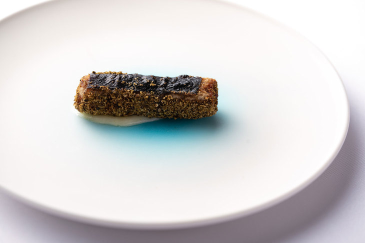 １皿目「久高島イラブーのシガレット」。イラブーの皮の薫香、身、だし、ビジュアルも含めてすべて生かした一品。