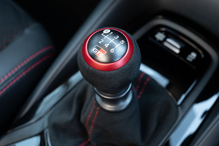 アルマイトレッドのリングが目を引くシフトセレクター。ドライブトレインでは6段MTの1速と3速のギア比を「RZ」から変更したほか、デファレンシャルギアをローギアード化して加速性能を向上。1、3、4、5速とデファレンシャルギアに高強度ギア材とショット処理を施すなど、耐久性の向上も図っている。