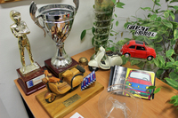 モデルカーや地元ラリーのトロフィーが卓上に。聞けば、前述のエンツォの肖像も含め、かつてエミリアーノさんの上司だった、以前の事務所オーナーが残していったものという。かなりの自動車愛好家だったとみえる。