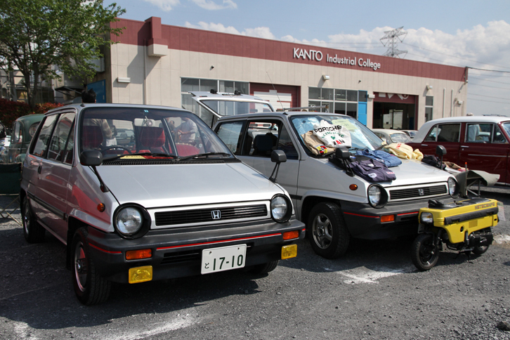 2台並んだ同色の1982年「ホンダ・シティ」。右側の前にはシティと同時にデビューした、ラゲッジルームに収まる原付バイクである「モトコンポ」の姿も。