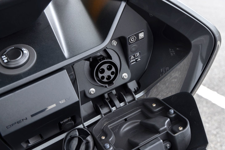 充電口はフロントカウルの内側に設置。満充電までに要する時間は、単相200V 15Aの普通充電で約4時間、単相200V 32Aのクイックチャージで約1時間20分とされている。