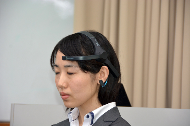 「感性アナライザ」は写真のヘッドセットで脳波を計測。「iPad」などの端末に計測結果を表示するシステムとなっている。