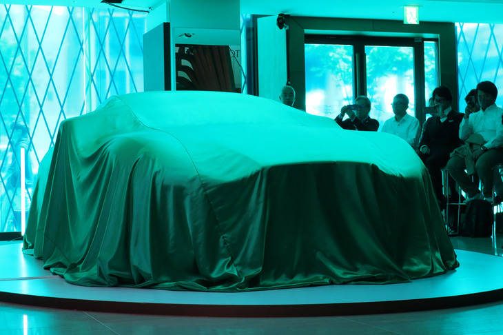 ステージ上にて、ベールで隠された「アストンマーティンDB12」。