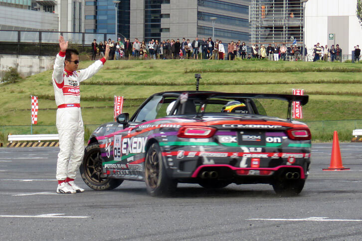 後輪を滑らせ、“人間パイロン”のまわりでターンを繰り返す山野哲也選手。近い、近い。近すぎる。