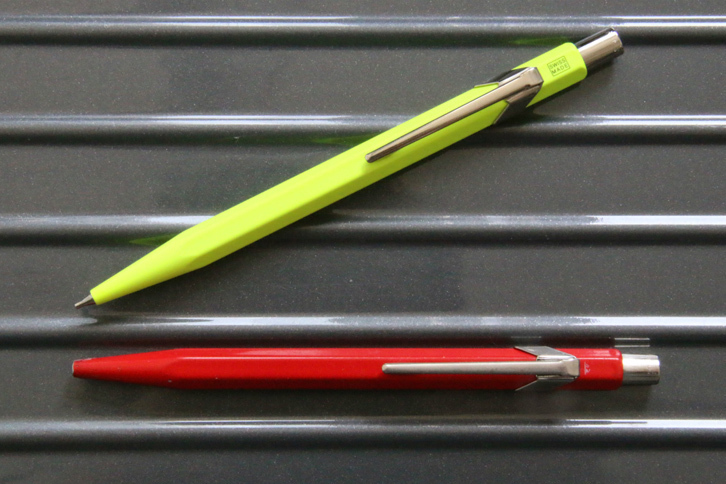 筆者が愛用しているカランダッシュのボールペン（下）。使っているうちノック部近くにあった「SWISS MADE」の文字は消えたが、鮮やかなレッドは色あせない。上はシャープペンシル。