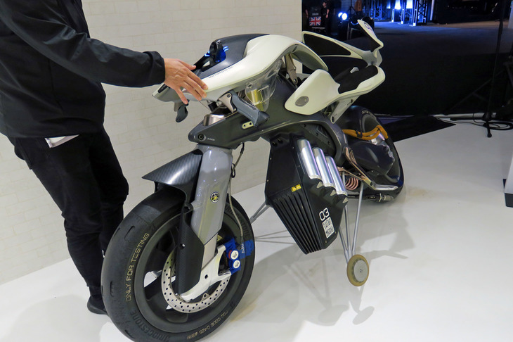 「MOTORiD」は“倒れないバイク”として自立し、低速で自動走行するロボットバイク。当時の柳 弘之社長のデモンストレーションは本当に衝撃的だった。さっそく記者も体験させていただく。まず自立モードでは、後輪と車体下部の重り（バッテリー）を巧みに動かし、車体のバランスをとる。多少手で押しても、倒れません。