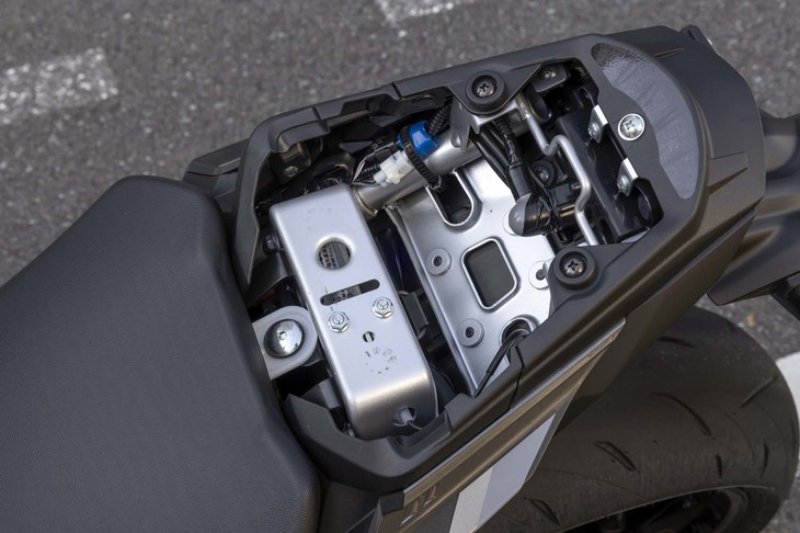 タンデムシート（後席）の下には、わずかながら小物入れスペースが確保されている。ヘルメットホルダーも装備。