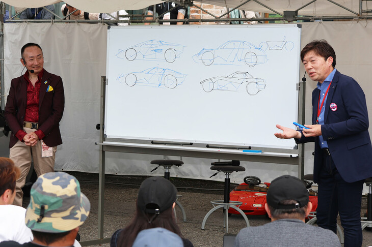 現行「ND」型をデザインした元デザイン本部長 中山 雅さん（写真向かって右）による、スポーツカーデザイン講座。ランボルギーニの「ミウラ」と「カウンタック」、また「ポルシェ911」のデザインを引き合いに、なぜNDのスタイリングが生まれたのかを解説した。現場で、これらのスポーツカーの線画をすらすらと描き上げてしまうのだから、やはりカーデザイナーはすごい。