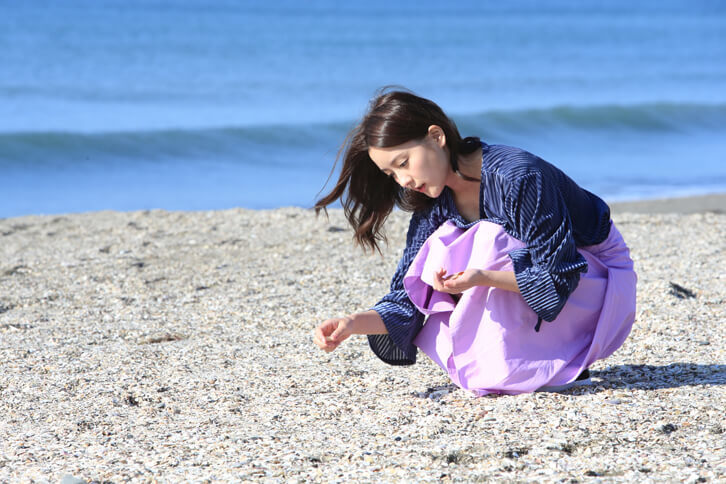 キャンドル作りに使う貝殻を探す生田さん。シーグラス（波にもまれて角の取れたガラス片）も探していたそうだが、今回は見つからなかった。