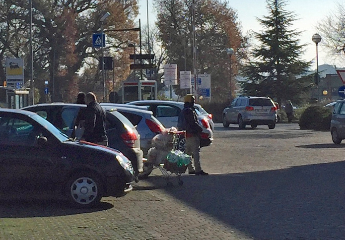 2016年12月、とあるスーパーでのひとこま。カートで買い物を終えた客がクルマに戻るや、さりげなく近づいてくるのが“買い物カート回収男”（写真中央）。