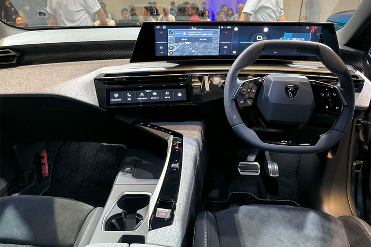 ダッシュボード上部のメーターと、メーターパネルより下方に位置する小径ステアリングホイールを組み合わせたプジョー独自の「iコックピット」は、「プジョーパノラミックiコックピット」に進化。表面がドライバーに向けてゆるやかにカーブする21インチのパノラミックスクリーンを採用している。