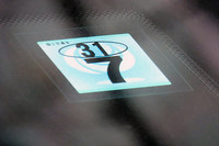 車検シールこと「検査標章」には、でかい文字で月の、小さい文字で和暦の年が記載されている。ちなみにこちらは古いデザインの検査標章。2017年1月からは、より表記がシンプルで、ひとまわりサイズも大きな検査標章が採用されている。