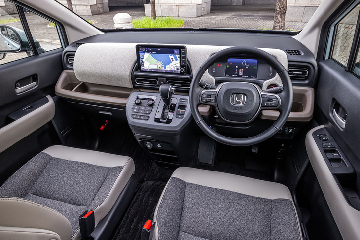 「シンプルな構成と使いやすさでこころに余裕をもたらす運転空間」をテーマに、水平基調でデザインされた新型「フリード」のインストゥルメントパネル。「エアー」（写真）では、ダッシュボード上部に柔らかなファブリックを用いて上質さを演出している。