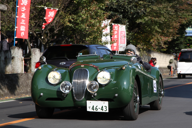 レーシングライクなモディファイが施された「ジャガーXK120」。沿道のギャラリーにラリー参加車両であることを知らせるため、ヘッドライトを点灯している。