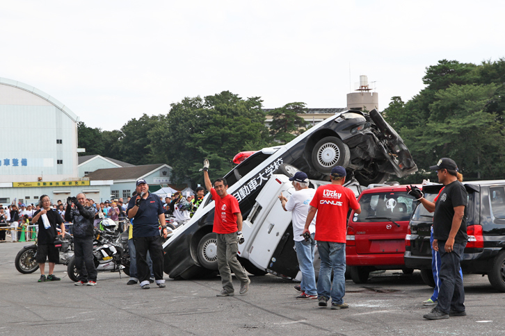 すべてのショーを終えたチームラッキーのスタッフ。真ん中で観客の声援に応え右手を挙げているのが、「マークII」パトカーを駆ったスゴ腕のベテランスタントドライバーの野呂真司氏。