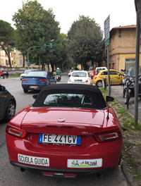 次の教習スロットを待つ「124スパイダー」。クルマ好きならずとも、通りすがりの人々が振り返るところからして、アイキャッチとしての費用対効果はバツグン!?