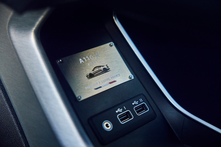 センターコンソール下の収納スペースに装着される、「A110 R」の専用プレート。各種空力パーツが目を引く車両のサイドビューと、シリアルナンバーが描かれている。