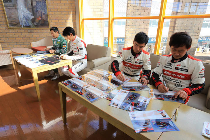 プロドライバー全員によるサイン会の実施。この後に行われた記念撮影でも、サイン色紙を掲げる人が見られるなど、イベント参加のいい記念品となったようだ。